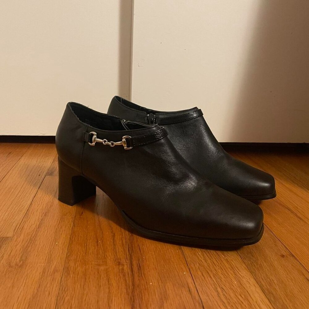Black leather ankle boots with silver buckles and a...